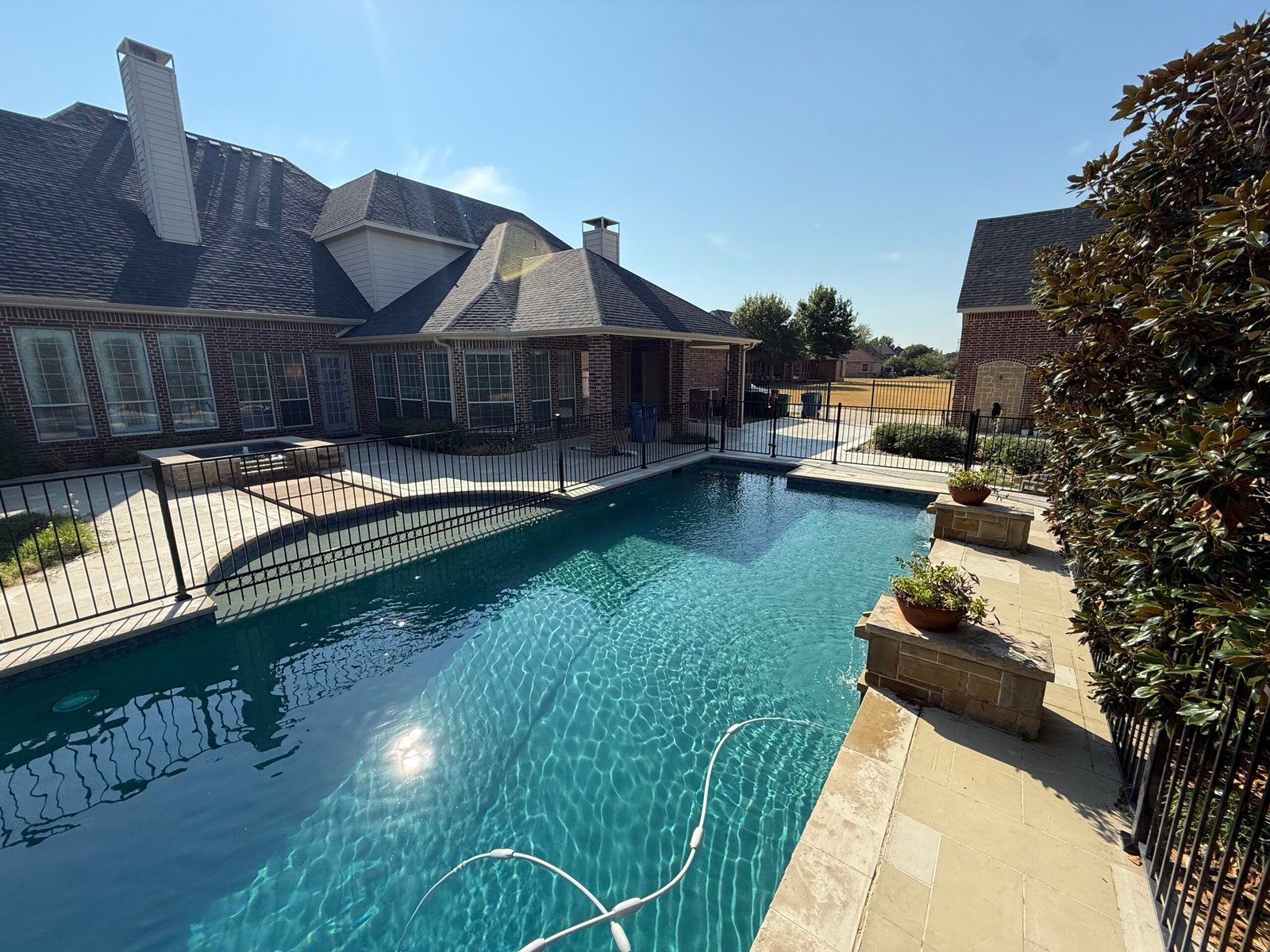 Custom galvanized pool fence installation around residential pool