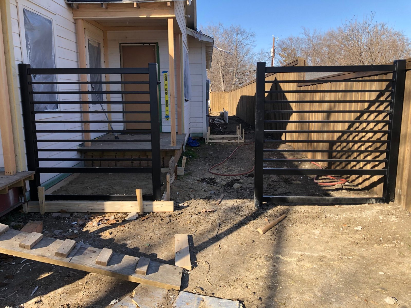 Powder-coated driveway gate protected before concrete pouring