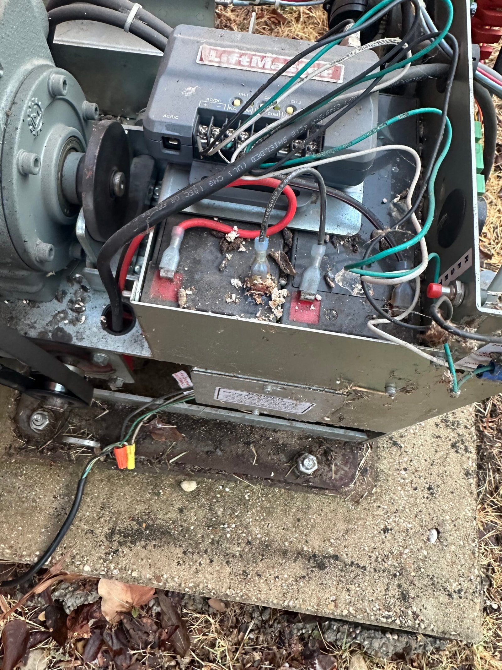 Existing battery pair inside an All-O-Matic sliding-gate operator before replacement
