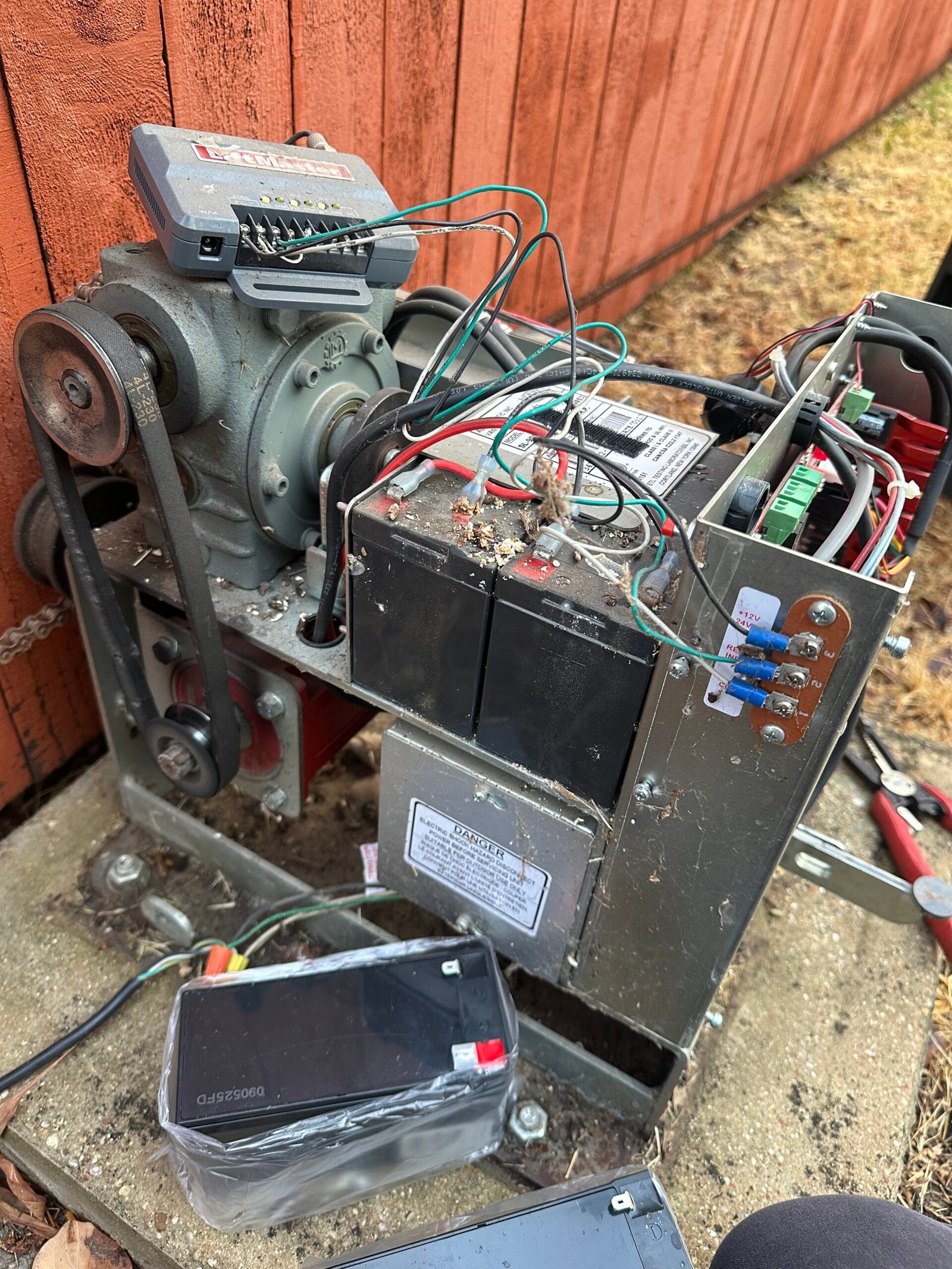 Battery replacement in progress inside an All-O-Matic sliding-gate operator